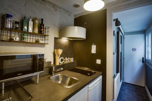 une cuisine avec un évier et une cuisinière dans l'établissement Le Cœur De La Scellerie - Hypercentre - Netflix, à Tours