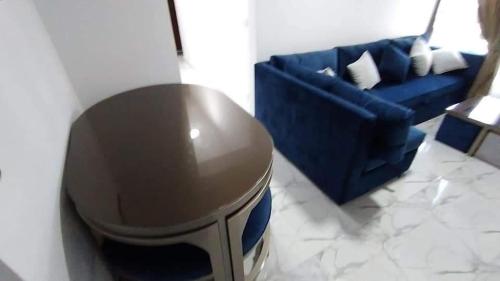 a living room with a blue couch and a table at شاليه ايجار شقق فندقي بورتو سعيد شالية غرفتين ورسيبشن و2 حمام ارضي بجاردن خاص Hotel chalet for rent in Porto Said in Ad Dībah
