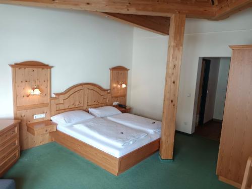 Schlafzimmer mit einem großen Bett und Holzmöbeln in der Unterkunft Hotel Grünwaldkopf in Obertauern