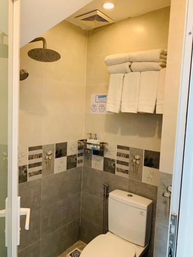 a bathroom with a toilet and towels on the wall at Carnival Villa in Da Lat