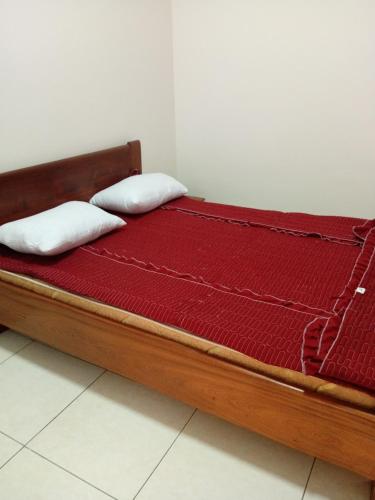 a bed with two pillows on top of it at KIM UNIVERSITY TWO ROOMS APARTMENT in Kigali