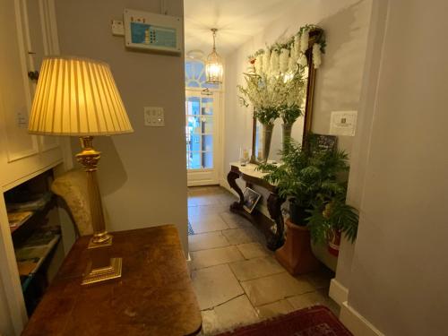 a hallway with a table and a lamp and a mirror at The Casterbridge in Dorchester