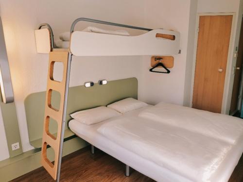 Łóżko piętrowe w niewielkim pokoju z drabiną w obiekcie ibis budget Berlin Ost w Berlinie