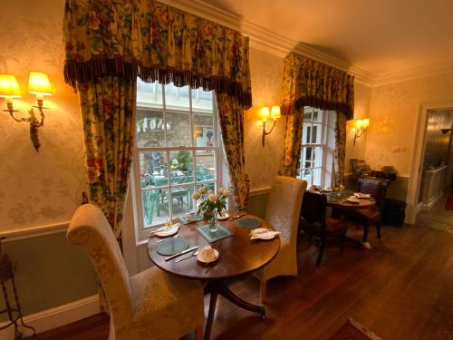a dining room with a table and chairs and a window at The Casterbridge in Dorchester