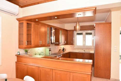 a kitchen with wooden cabinets and a sink at Kentos Airy & Fully Equipped 3BR Family Maisonette in Chios