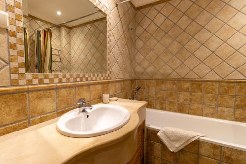 um banheiro com pia e banheira em Urban Beach - Casa MM em Carvoeiro