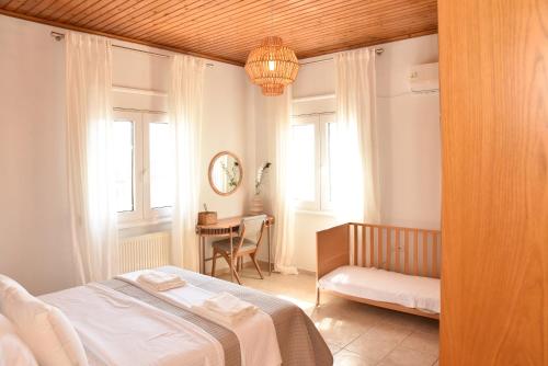 a bedroom with a bed and a table and window at Kentos Airy & Fully Equipped 3BR Family Maisonette in Chios