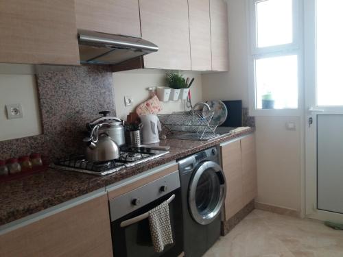 a kitchen with a stove and a washing machine at Shems Bouznika kettani in Bouznika