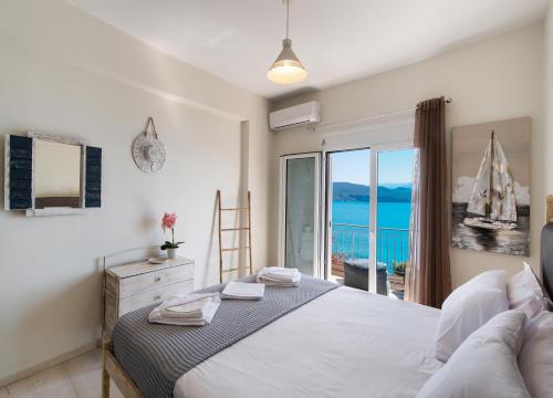 a bedroom with a bed with a view of the ocean at Meteora Suites in Nikiana