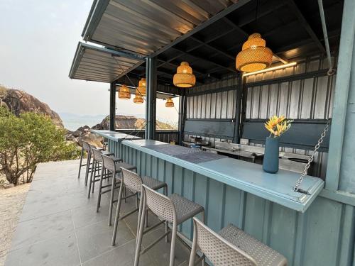 a bar with chairs and a counter with a view at Cintacor Island Resort in Kārwār