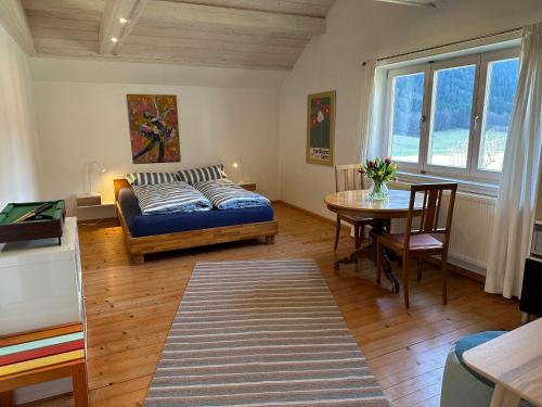 een woonkamer met een bed en een tafel bij Am Ampferang:Ferienhaus in Ettal in Ettal
