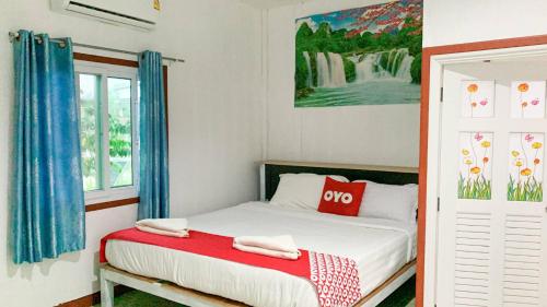 una camera da letto con un letto e un quadro sul muro di ตาลฟ้ารีสอร์ท (Tanfah Resort) a Ban Nong Khang