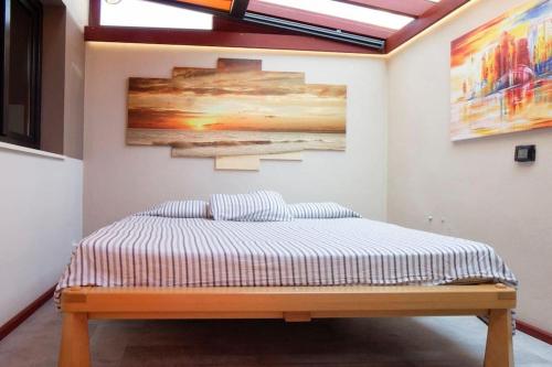 a bed in a room with a painting on the wall at Designer Haus mit beheiztem Pool (überdacht) in La Listada