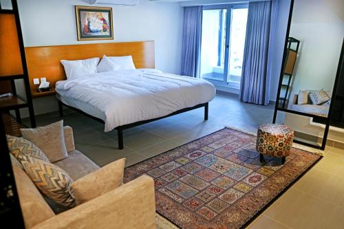 ein Schlafzimmer mit einem Bett und ein Wohnzimmer in der Unterkunft The Avenue Hotel in Islamabad