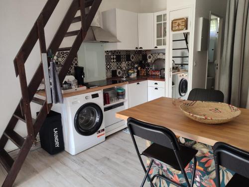 a kitchen with a washing machine and a wooden table at Villa club avec jardin in Bandol