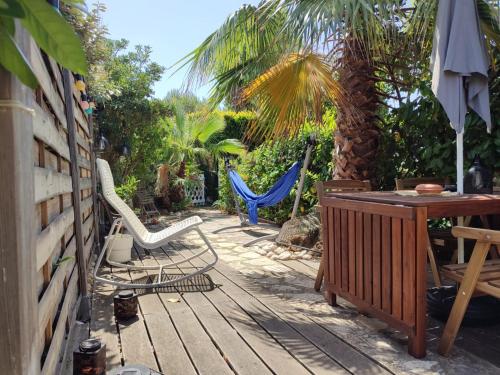 d'une terrasse avec un hamac, une table et des chaises. dans l'établissement Villa club avec jardin, à Bandol