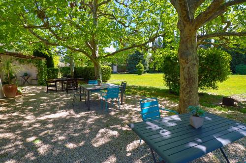 een blauwe picknicktafel en stoelen onder een boom bij Le Mas de Bertagne in Gémenos
