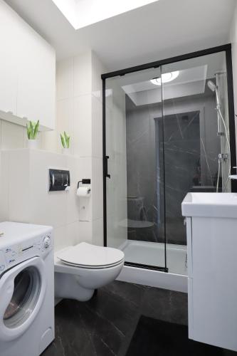 bagno bianco con servizi igienici e doccia di Pure Elegance Apartament a Gdynia