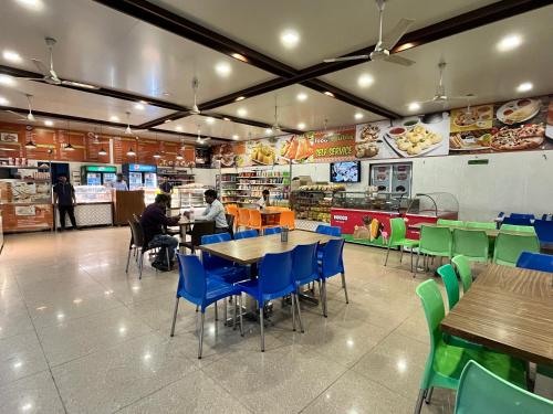 two people sitting at tables in a fast food restaurant at Hotel Grand Darshan Vadodara in Vadodara