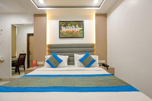 Schlafzimmer mit einem Bett mit blauen und weißen Kissen in der Unterkunft Hotel Bhartia- Couple Friendly Stay in Neu-Delhi