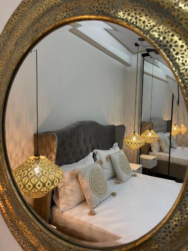 a mirror reflecting a bedroom with a bed with pillows at AGORA luxury APARTMENT 10 in Loutraki