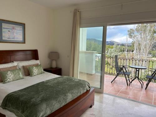 1 Schlafzimmer mit einem Bett und einem Balkon mit einem Tisch in der Unterkunft 5-Bed Villa Mijas La Cala Golf & Spa Resort in Mijas