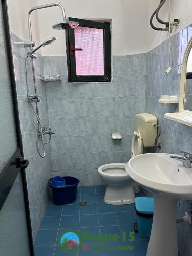 a bathroom with a toilet and a sink at Vogue Rooms in Golem