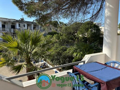 a balcony with a table and chairs and a palm tree at Vogue Rooms in Golem