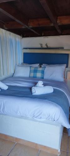 a blue bed with white sheets and pillows at Kynosoura's sea view in Ambelákia