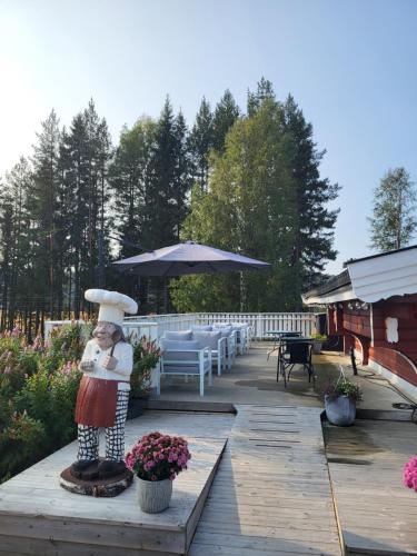 a wooden deck with a table and an umbrella at Neset Skydsstasjon in Flesberg