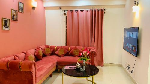 - un salon avec un canapé rouge et une table dans l'établissement Serene Home Apartment, à Islamabad