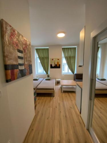 a living room with two beds and a kitchen at MINATO Apartments Ostrava center in Ostrava