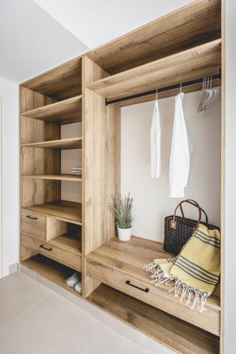 a dressing room with a wooden cabinet with shelves at Votsalo Tolo in Tolo