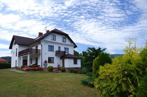 a white house with balconies on a lawn at Willa Tulipan in Kamienica