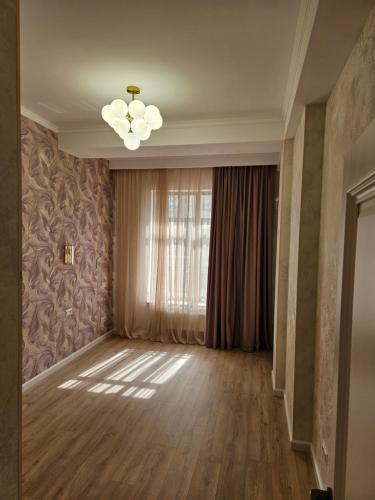 sala de estar con lámpara de araña y ventana en French kvartal en Bishkek