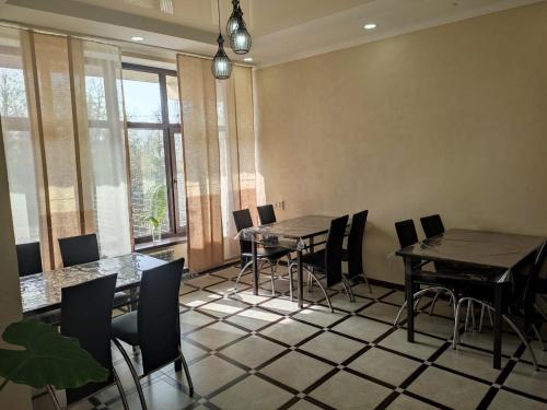- une salle à manger avec 2 tables, des chaises et des fenêtres dans l'établissement hotel Tourist, à Karakol