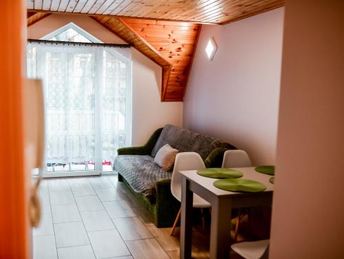 a living room with a couch and a table at Apartament EmKa z balkonem Rowy in Rowy