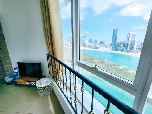 a room with a balcony with a view of the ocean at Comfy Studio with Stunning Vista, Pool and Gym in Abu Dhabi