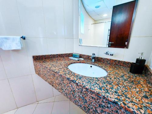 a bathroom counter with a sink and a mirror at Comfy Studio with Stunning Vista, Pool and Gym in Abu Dhabi