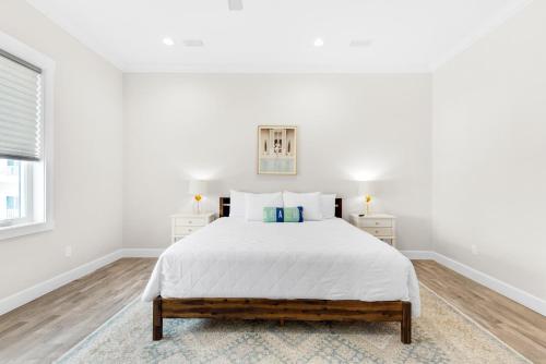 a white bedroom with a bed and two night stands at Nonni 'N Poppy's in Navarre