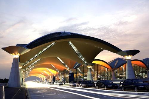 Kepler Club Kuala Lumpur Airport - KLIA T1 Landside في سيبانغ: مبنى كبير فيه سيارات تقف على شارع