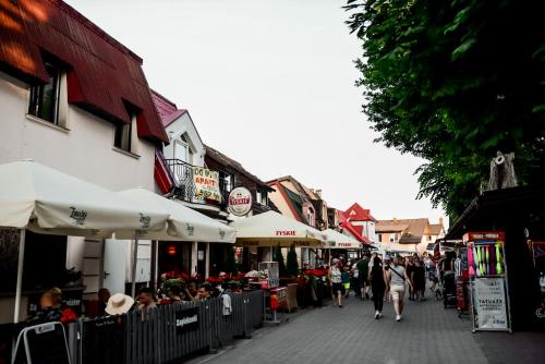 a group of people walking down a street at Apartament EmKa z balkonem Rowy in Rowy