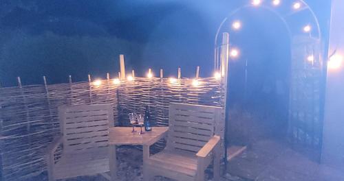 a table with two chairs and a bottle of wine at The Manse featuring the Daisy Camrose in Haverfordwest