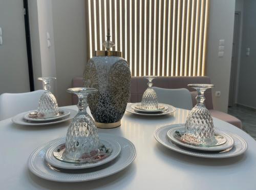 a table with four plates and a vase on it at AGORA luxury APARTMENT 10 in Loutraki