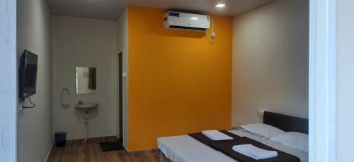 Aaryan Beach Resort في Murūd: غرفة بسرير جدارها اصفر