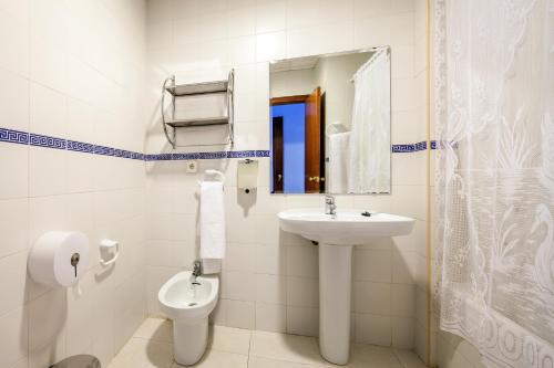 a bathroom with a sink and a toilet and a mirror at Hotel Restaurante Los Molinos in Écija