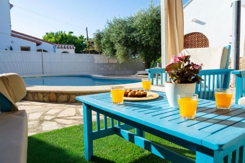 un tavolo blu con piatto di cibo e succo d'arancia di Casa Delicias con Piscina Privada a 200m playa - By Marina Alta Holidays a Denia