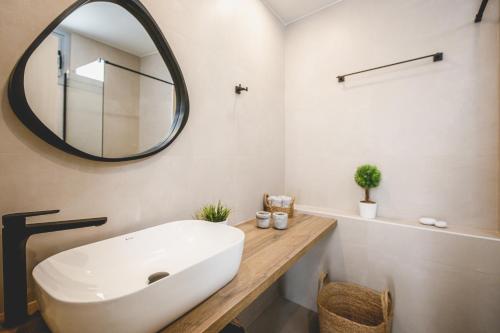 a bathroom with a large white sink and a mirror at Votsalo Tolo in Tolo