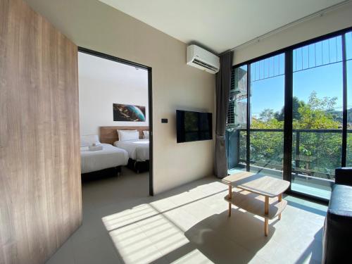 Habitación con 1 dormitorio con 1 cama y 1 mesa. en Double J Hotel en Chiang Mai