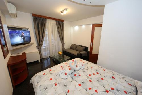 a bedroom with a bed and a couch and a tv at Villa Maki in Ohrid
